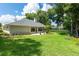 Spacious backyard with grassy area, mature trees, and privacy hedge at 2215 Se Spring Hill Ct, Ocala, FL 34471