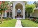 Elegant home entrance with lush landscaping and double doors at 2215 Se Spring Hill Ct, Ocala, FL 34471