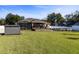 Expansive backyard featuring a screened-in porch, an in-ground pool, lush lawn, and a well-maintained garden at 36323 Piney Ridge Blvd, Fruitland Park, FL 34731