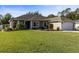 Beautiful home exterior featuring a two-car garage, lush lawn, charming landscaping, and well-kept garden beds at 36323 Piney Ridge Blvd, Fruitland Park, FL 34731