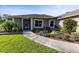 Inviting front entrance showcasing a well-manicured garden with a charming water feature and a concrete walkway at 36323 Piney Ridge Blvd, Fruitland Park, FL 34731