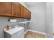 Laundry room with utility sink, overhead cabinets, and tile floors at 36323 Piney Ridge Blvd, Fruitland Park, FL 34731