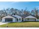 Modern single story home with a white exterior, gray roof, and a two-car garage at 4216 Se 7Th Pl, Ocala, FL 34471