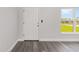 Bright entryway featuring wood-look flooring, white trim, and a secure front door with modern hardware at 4393 Sw 169 Lane Rd, Ocala, FL 34473
