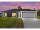 Charming one-story home showcasing a modern gray and white exterior with well-manicured lawn and an ample driveway at 4393 Sw 169 Lane Rd, Ocala, FL 34473