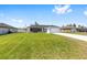 Charming single-story home featuring a gray and white exterior, a spacious driveway, and a well-manicured lawn at 4393 Sw 169 Lane Rd, Ocala, FL 34473