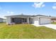 Charming one-story home showcasing a modern gray and white exterior with well-manicured lawn and an ample driveway at 4393 Sw 169 Lane Rd, Ocala, FL 34473