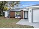 Inviting front yard view with a well-maintained lawn and modern architectural details on the home's facade at 4393 Sw 169 Lane Rd, Ocala, FL 34473