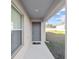 Covered entryway with a gray door and adjacent window at 4955 Se 89Th Place Rd, Ocala, FL 34480