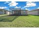 View of backyard, showcasing the house and screened porch at 5624 Sw 88Th Ave, Ocala, FL 34481