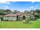 One-story home with green exterior, brown roof, and landscaped yard at 7451 Se 24Th Ter, Ocala, FL 34480