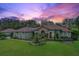 House exterior at sunset, landscaping and American flag visible at 7451 Se 24Th Ter, Ocala, FL 34480