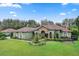 Green house with brown roof and landscaping, American flag visible at 7451 Se 24Th Ter, Ocala, FL 34480