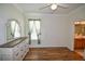 Bedroom with wood-look flooring, a dresser, and access to the bathroom at 8852 Se 119Th St, Summerfield, FL 34491