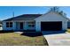 Newly built home with a gray exterior and black garage door at 8968 Se 156Th St, Summerfield, FL 34491