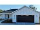 Modern farmhouse exterior with dark garage door at 8968 Se 156Th St, Summerfield, FL 34491