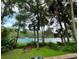 Picturesque lake view with lush greenery, boats, and people enjoying water activities under a serene sky at 9625 Sw 207Th Cir, Dunnellon, FL 34431