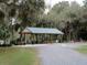 Spacious outdoor picnic pavilion with tables, ideal for gatherings in a park-like setting, surrounded by green landscape at 9625 Sw 207Th Cir, Dunnellon, FL 34431