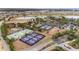 Aerial view of the community's tennis and pickleball courts near a lake and residential area at 10129 Sw 77Th Loop, Ocala, FL 34481