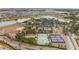 Aerial view of the community's tennis and pickleball courts with lake and surrounding houses at 10129 Sw 77Th Loop, Ocala, FL 34481