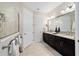 Bathroom with dual vanity sinks, a large mirror, and a glass-enclosed walk-in shower at 10129 Sw 77Th Loop, Ocala, FL 34481