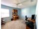 Cozy bedroom with light blue walls, ceiling fan, and built-in workspace at 1033 Sw 159Th St, Ocala, FL 34473