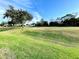 Picturesque view of a golf course with mature trees and a putting green at 1033 Sw 159Th St, Ocala, FL 34473