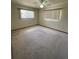 A spacious bedroom with neutral walls, carpet, and natural light from two windows at 10949 Sw 79Th Ter, Ocala, FL 34476