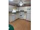Bright kitchen with white cabinets, appliances, and wood-look flooring for a classic design at 10949 Sw 79Th Ter, Ocala, FL 34476