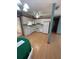 A white kitchen with wood-look flooring, white appliances, and view to screened porch at 10949 Sw 79Th Ter, Ocala, FL 34476