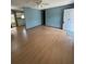 A spacious living room with wood-look floors that leads to the kitchen and front door at 10949 Sw 79Th Ter, Ocala, FL 34476