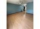Spacious living room with wood-look flooring, blue accent wall, and light natural light at 10949 Sw 79Th Ter, Ocala, FL 34476