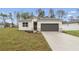 Charming single-story home featuring a well-manicured lawn and a modern two-car garage at 13143 Sw 67Th Ave, Ocala, FL 34473