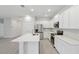 Modern kitchen featuring sleek white cabinets, stainless steel appliances, quartz countertops, and an island with sink at 13143 Sw 67Th Ave, Ocala, FL 34473