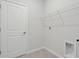 Bright laundry room with tile floor, white door, overhead wire shelving, and hookups at 13143 Sw 67Th Ave, Ocala, FL 34473