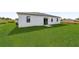White house with sliding glass doors and a large grassy backyard at 13299 Sw 77Th Ave, Ocala, FL 34473