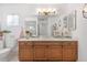 Clean bathroom with wood cabinets and a large vanity mirror at 17999 Se 99Th Ave, Summerfield, FL 34491