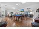 Spacious game room with pool table, hardwood floors, and large windows at 17999 Se 99Th Ave, Summerfield, FL 34491