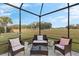 Screened-in patio with seating and golf course view at 17999 Se 99Th Ave, Summerfield, FL 34491