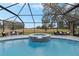 Enjoy this screened-in pool and spa with a golf course view at 17999 Se 99Th Ave, Summerfield, FL 34491