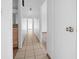 Hallway with light beige tile floors and doors to other rooms at 20 Pine Trace Run, Ocala, FL 34472