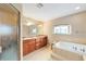 Bathroom featuring double vanity sinks, a garden tub, and a separate glass-enclosed shower at 2105 Sw 4Th St, Ocala, FL 34471