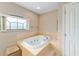 Bathroom featuring a large garden tub with tile surround and a privacy window at 2105 Sw 4Th St, Ocala, FL 34471
