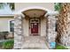 Inviting front entrance featuring stone pillars and a classic red door with decorative details at 2105 Sw 4Th St, Ocala, FL 34471