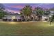 Beautiful sunset view of the exterior featuring mature palms and a manicured front lawn at 2105 Sw 4Th St, Ocala, FL 34471
