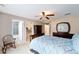 Relaxing main bedroom featuring a ceiling fan, large bed, rocking chair, and en-suite bath at 2105 Sw 4Th St, Ocala, FL 34471