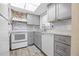 Modern kitchen with gray cabinets and white appliances at 22202 Sandalwood Dr # 202, Wildwood, FL 34785