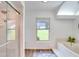 Relaxing bathroom with soaking tub, shower, and large window at 2263 Se Laurel Run Dr, Ocala, FL 34471