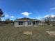New home with a gray exterior, brown roof, and an outdoor patio and yard at 3 Willow Trl, Ocala, FL 34472