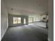 Spacious, open-plan living area with neutral walls, new carpeting, and abundant natural light from multiple windows at 3 Willow Trl, Ocala, FL 34472